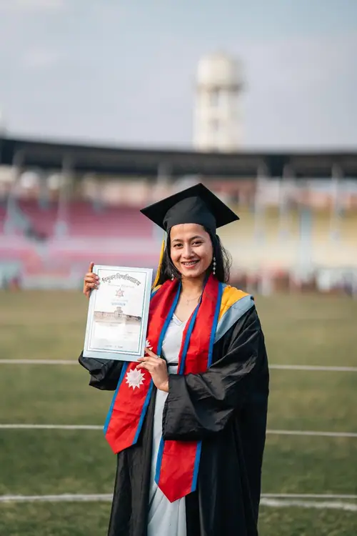 Kushum holding her Tribhuvan University certificate